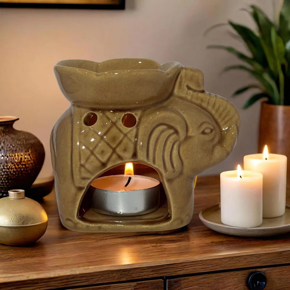 Decorative candle warmer with lit candles on a wooden surface