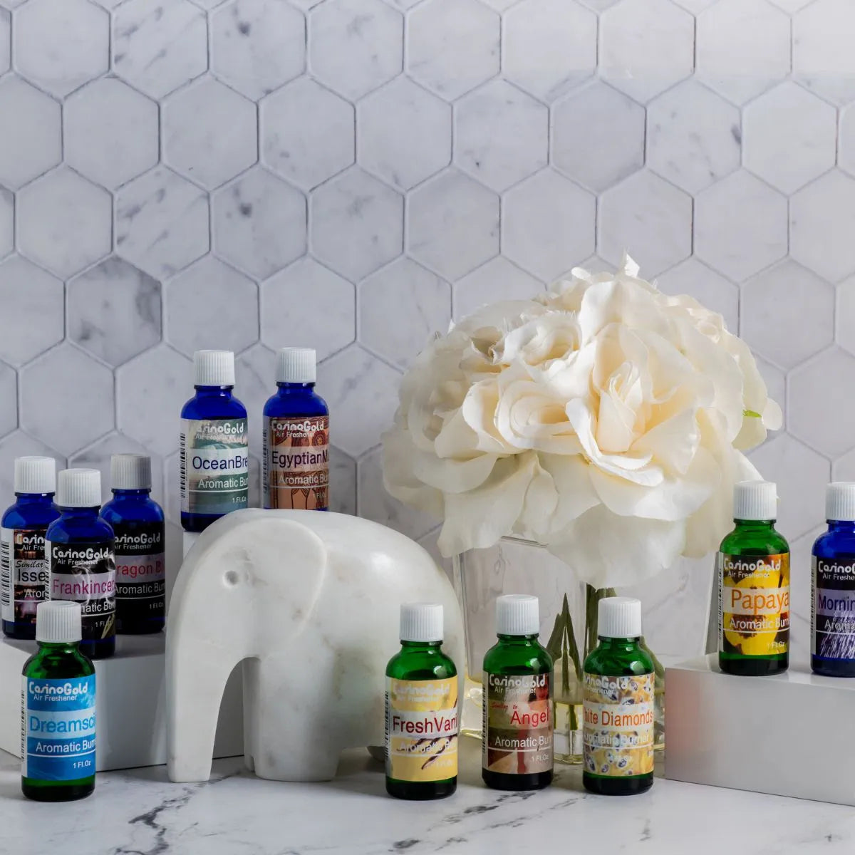 Elegant home display of Casino Gold fragrance oils with flower decor and ceramic elephant