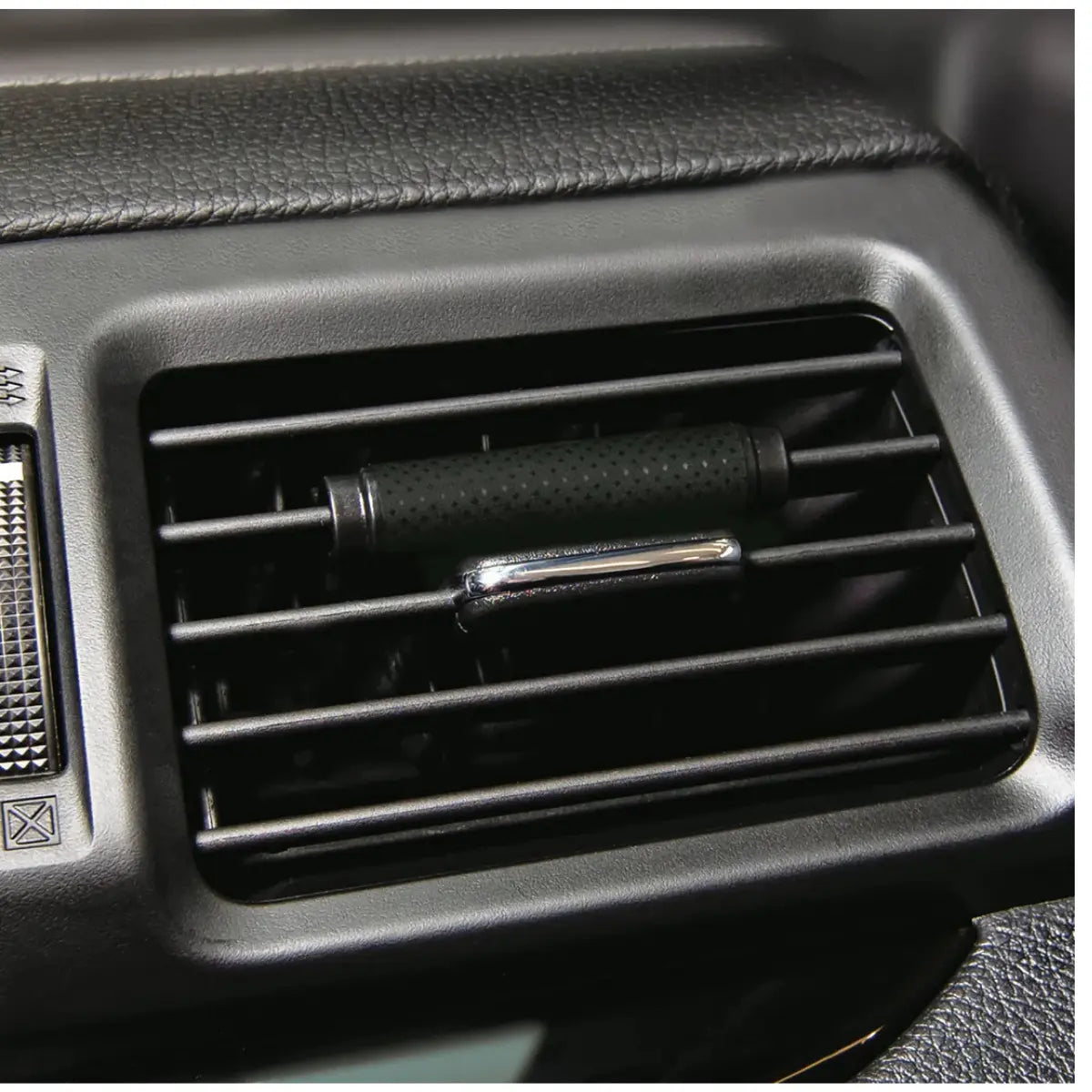 Little Trees Caribbean Colada Vent Wrap clipped onto a car vent, showing sleek, low-profile placement.